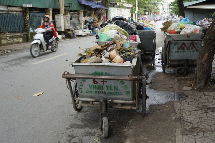 Nhiều con phố khá hẹp như phố Trần Bình nhưng ngày nào cũng tồn tại hàng chục xe rác ngay dưới lòng đường suốt cả ngày. Vừa mất mĩ quan và thường xuyên gây ra tình trạng ùn tắc giao thông ở khu vực này. Ảnh: Tùng Dương. Nhiều con phố khá hẹp như phố Trần Bình nhưng ngày nào cũng tồn tại hàng chục xe rác ngay dưới lòng đường suốt cả ngày. Vừa mất mĩ quan và thường xuyên gây ra tình trạng ùn tắc giao thông ở khu vực này. Ảnh: Tùng Dương.