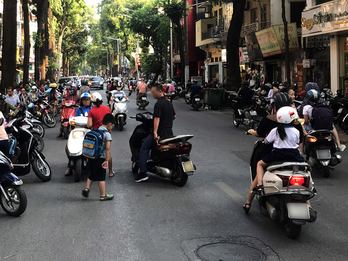 Nhiều phụ huynh đón con ngay giữa đường trên phố Lò Đúc. Ảnh: Tùng Dương.