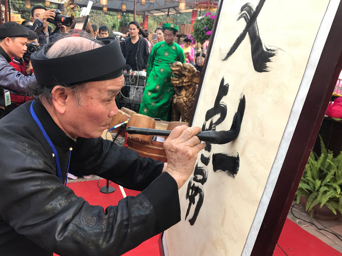 Cụ Nguyễn Như Phách thể hiện nét bút tại lễ hội. Ảnh: Tùng Dương.