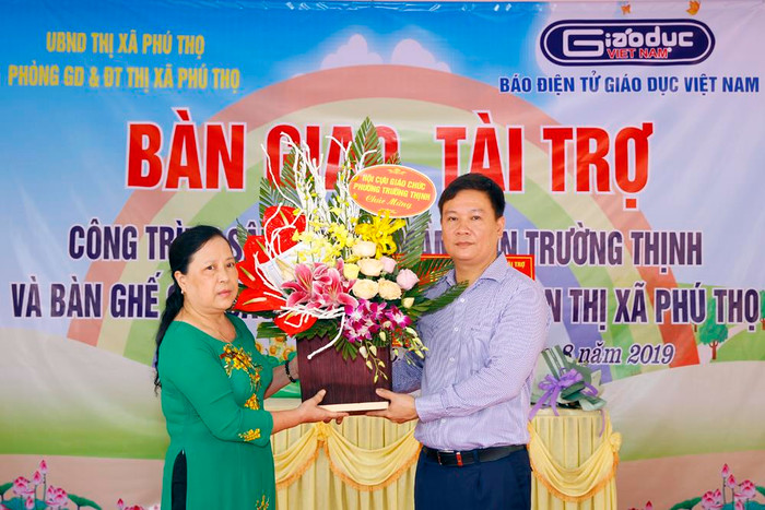 Nhà giáo ưu tú Hoàng Thị Hựu thay mặt Hội cựu giáo chức và hội cha mẹ học sinh của phường Trường Thịnh tăng hoa và tỏ lòng cảm ơn đối với Nhà báo Nguyễn Tiến Bình. Ảnh: Tùng Dương. Nhà giáo ưu tú Hoàng Thị Hựu thay mặt Hội cựu giáo chức và hội cha mẹ học sinh của phường Trường Thịnh tăng hoa và tỏ lòng cảm ơn đối với Nhà báo Nguyễn Tiến Bình. Ảnh: Tùng Dương.