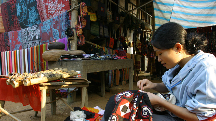 Người Thái trắng tại bản Lác ngồi thêu khăn ngay dưới hiên nhà. Ảnh: Tùng Dương.