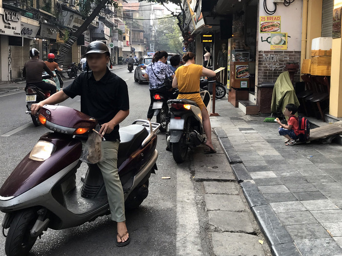 Phụ huynh đi ngược chiều sau khi đưa con đến trường, Trường tiểu học Hồng Hà - phố Chả Cá, Hà Nội. Ảnh: Tùng Dương.