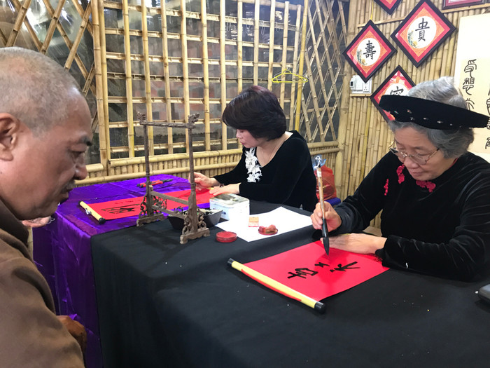 Tại lễ hội năm nay, các bà, các chị cũng tham gia biểu diễn thư pháp. Ảnh: Tùng Dương.