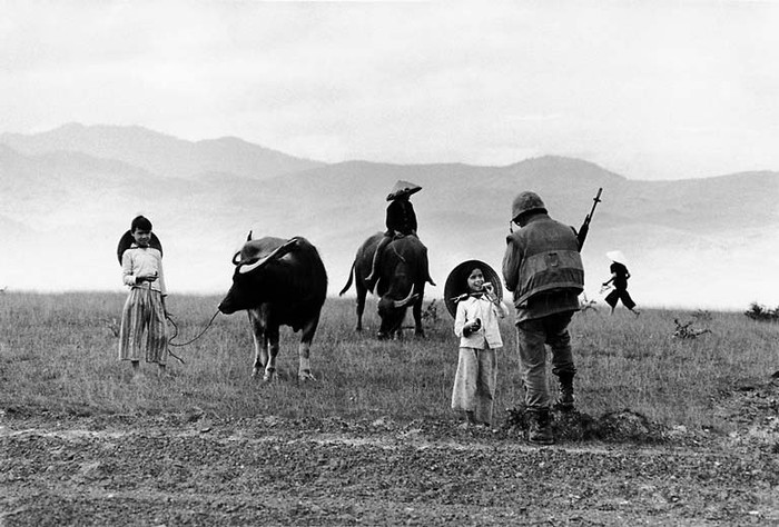 Một lính thủy đánh bộ Mỹ đang tặng thuốc lá cho một em nhỏ chăn trâu.