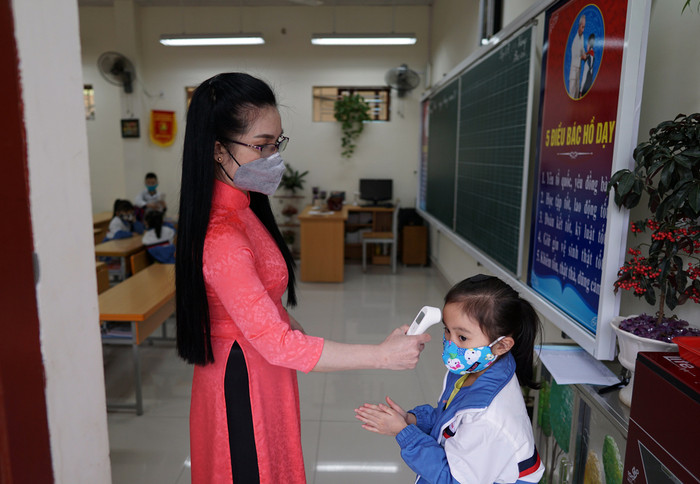 Giáo viên Trường Tiểu học Nguyễn Công Trứ (quận Lê Chân) đo nhiệt độ cơ thể cho học sinh trước khi vào lớp (Ảnh: LT) Giáo viên Trường Tiểu học Nguyễn Công Trứ (quận Lê Chân) đo nhiệt độ cơ thể cho học sinh trước khi vào lớp (Ảnh: LT)