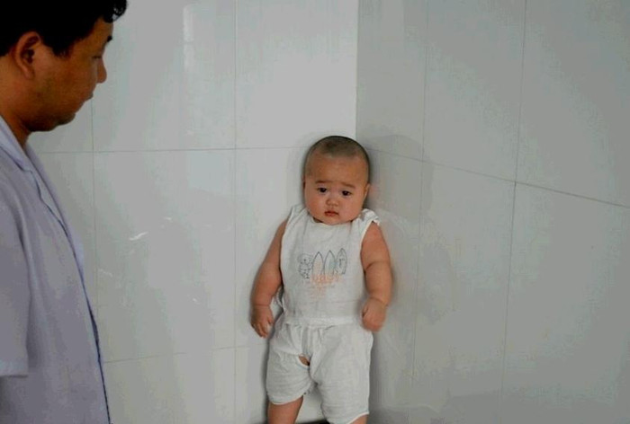 Vẫn đứng dán vào góc tường mặc dù đang được mẹ khuyên giải.