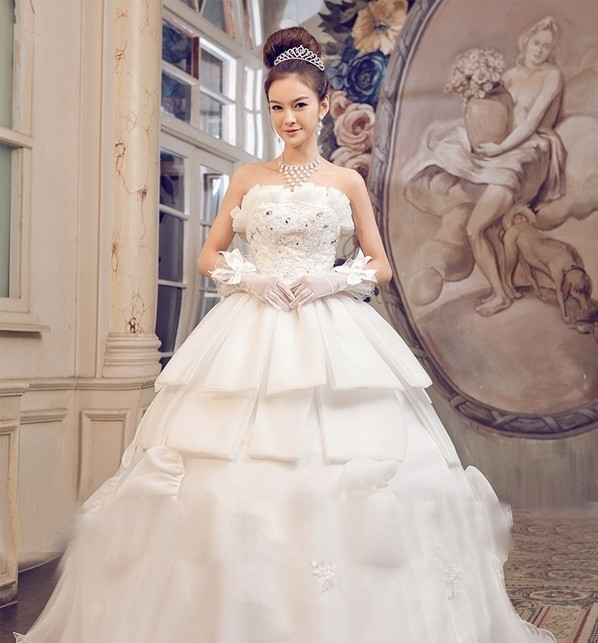 Một chút cổ điển với tóc vấn cao, cài vương miện xinh xắn. Chiếc váy độc đáo với phần thân váy xếp tầng đơn giản, ít diêm dúa mà vẫn điệu đà, cuốn hút. (Ảnh:H) Xem thêm: Thời trang váy cưới 2012 / Bộ sưu tập váy xinh dành cho quý cô công sở.