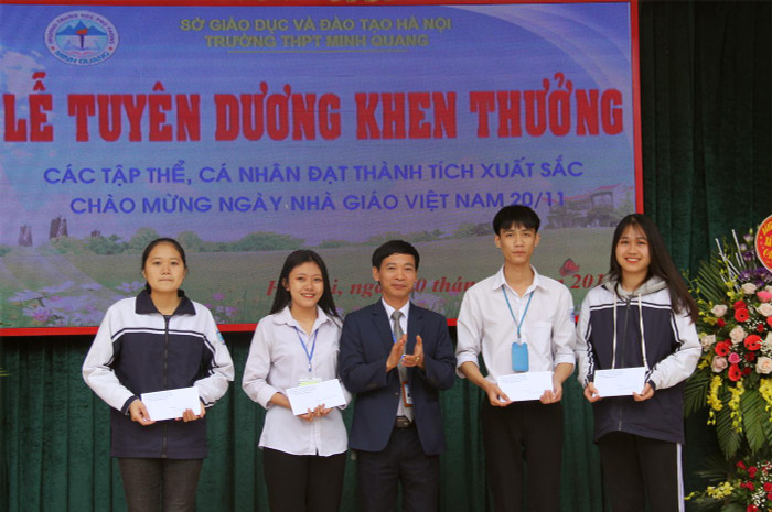 Thầy Nguyễn Duy Bỉnh - Hiệu trưởng Trường Trung học phổ thông Minh Quang (người đứng giữa) tại lễ tuyên dương học sinh giỏi của trường. Ảnh: NVCC. Thầy Nguyễn Duy Bỉnh - Hiệu trưởng Trường Trung học phổ thông Minh Quang (người đứng giữa) tại lễ tuyên dương học sinh giỏi của trường. Ảnh: NVCC.