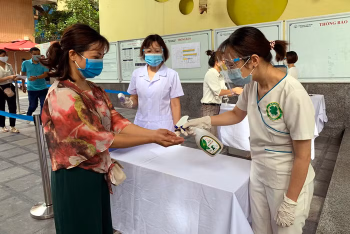 Diễn tập đo thân nhiệt sát khuẩn tay các thí sinh đến dự thi. Ảnh: Tùng Dương.