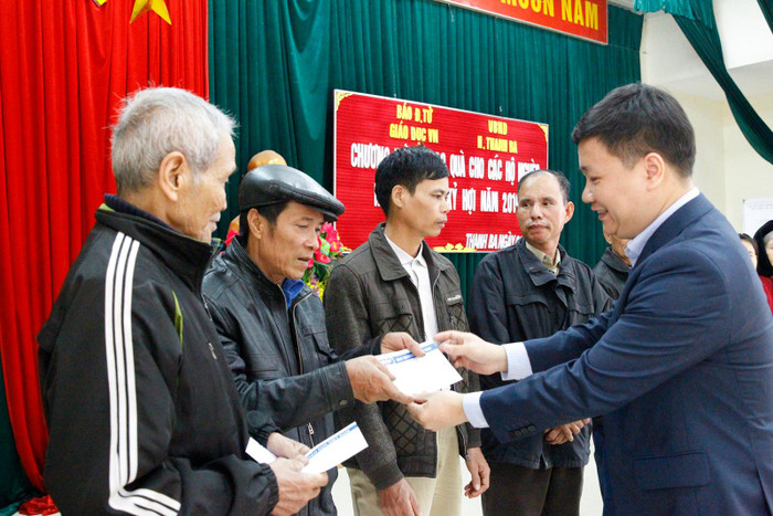 Nhà báo Nguyễn Tiến Bình tặng quà và động viên các gia đình: “Cần phải cố gắng cho con em được học hành đến nơi đến chốn, dù có khó khăn thế nào cũng phải cố gắng khắc phục để các cháu được đến trường”. Ảnh: Tùng Dương.