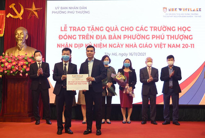 Thầy giáo Đàm Tiến Nam – Hiệu trưởng Trường Nguyễn Bình Khiêm, Cầu Giấy đang trao bộ thiết bị phòng họp trực tuyến cho ông Nguyễn Công Quảng - Phó Bí thư Đảng Uỷ - Chủ tịch UBND phường Phú Thượng. Ảnh: NTCC. Thầy giáo Đàm Tiến Nam – Hiệu trưởng Trường Nguyễn Bình Khiêm, Cầu Giấy đang trao bộ thiết bị phòng họp trực tuyến cho ông Nguyễn Công Quảng - Phó Bí thư Đảng Uỷ - Chủ tịch UBND phường Phú Thượng. Ảnh: NTCC.
