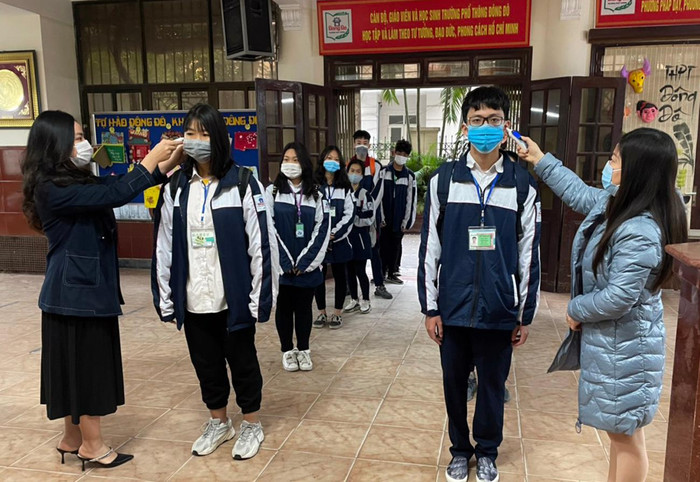 Các giáo viên chủ nhiệm của Trường Trung học phổ thông Đông Đô, quận Tây Hồ, Hà Nội được phân công đo thân nhiệt, nhắc nhở cán bộ giáo viên, học sinh luôn đeo khẩu trang, sát khuẩn tay đảm bảo việc giãn cách an toàn. Ảnh: Tùng Dương.