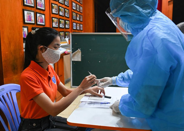 Tình huống phát hiện một thí sinh có thân nhiệt cao (trên 37,5 độ), sau khi đo lại 3 lần vẫn cao. Ngay lúc đó, nhân viên y tế đưa thí sinh vào phòng cách ly tạm thời, điều tra dịch tễ và đo lại thân nhiệt bằng nhiệt kế thủy ngân. Sau thời gian nghỉ ngơi, thí sinh đo lại thân nhiệt và nếu bình thường sẽ tiếp tục làm thủ tục vào phòng thi. Ảnh: G.H.