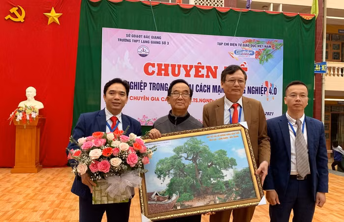 (Từ trái qua phải) Thầy Nguyễn Huy Nghĩa - Phó hiệu trưởng, Giáo sư Nguyễn Lân Dũng, thầy Nguyễn Văn Nam - Hiệu trưởng và thầy Trương Văn Giáp - Phó hiệu trưởng, tặng hoa, chụp ảnh lưu niệm với Giáo sư Nguyễn Lân Dũng. Ảnh: Tùng Dương.