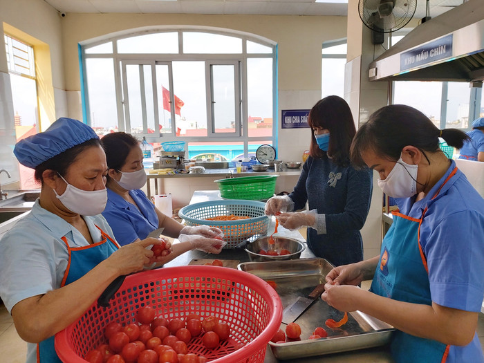 Cán bộ, giáo viên, nhân viên chuẩn bị thực phẩm nấu bữa ăn trưa cho người cách ly (Ảnh: Lã Tiến)