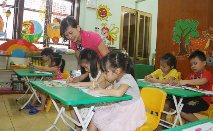 Cô giáo Nguyễn Thị Nam hướng dẫn học sinh lớp 5 tuổi trong giờ hoạt động tạo hình (Ảnh: N.D)