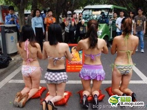 Bốn cô gái trẻ mặc bikini quỳ lạy trước ảnh của Đức Phật ngay giữa đường trước sự hiếu kỳ của người dân địa phương.