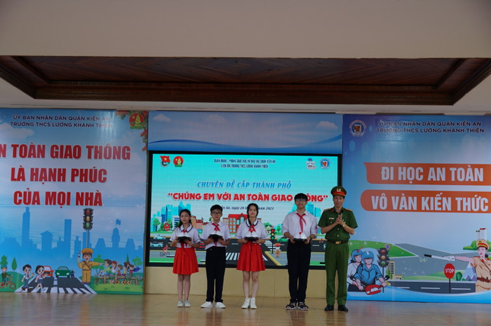 Lãnh đạo Công an quận Kiến An trao mũ bảo hiểm tặng học sinh nhà trường (Ảnh: LT)