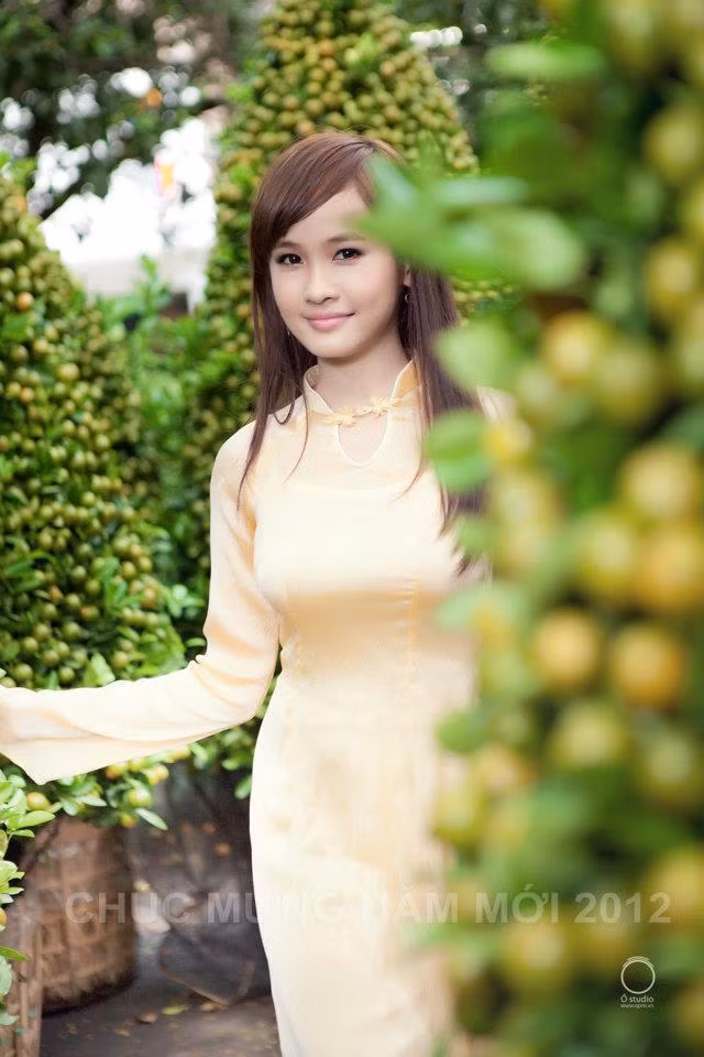 Nét trẻ thơ vẫn nồng đượm trên gương mặt cô gái này. Tà áo dài màu vàng mơ tôn lên vẻ đẹp yêu kiều thiếu nữ.