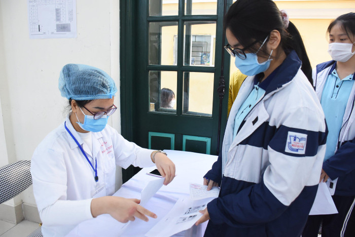 Nhân viên y tế kiểm tra danh sách học sinh đăng ký tiêm (Ảnh: NH) Nhân viên y tế kiểm tra danh sách học sinh đăng ký tiêm (Ảnh: NH)