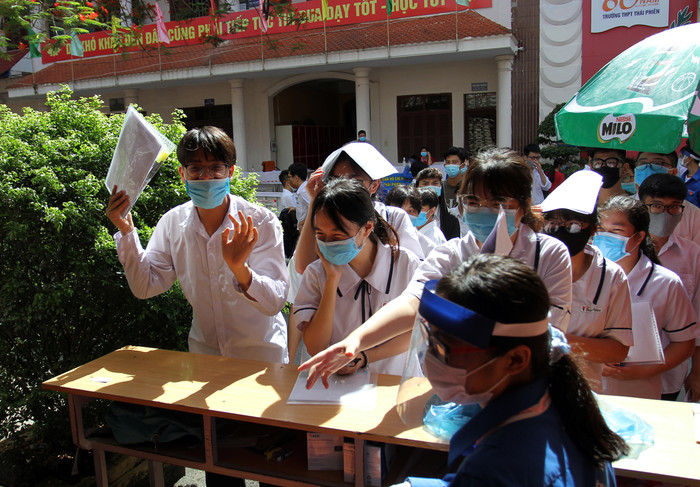 Các thí sinh lấy đồ dùng cá nhân sau khi làm thủ tục dự thi (Ảnh: Lã Tiến)