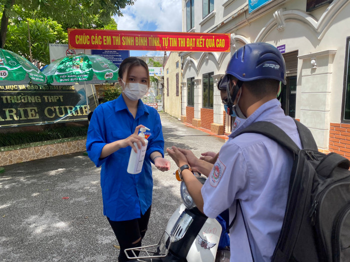 Các thí sinh đến điểm thi làm thủ tục dự thi được sát khuẩn tay (Ảnh: Lã Tiến)