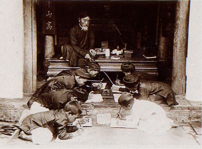 Thầy đồ cầm roi, ngồi trên sập gụ dạy lũ học trò làng chữ Nho.