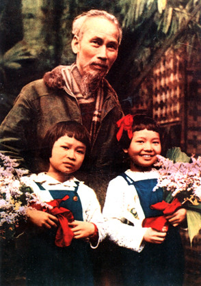 Bác Hồ chụp ảnh với 2 cháu thiếu nhi Vũ Thu Giang (bên trái) và Đặng Minh Châu (bên phải). Những ngày ấy, bé Vũ Thu Giang, lúc đó mới 7 tuổi, thường chơi đùa ở cơ quan của mẹ, một cán bộ trí thức giữ cương vị nòng cốt trong Trung ương Hội phụ nữ Việt Nam, gần nơi tổ chức đại hội. Trong giờ nghỉ, bé Thu Giang và Đặng Minh Châu (con gái của Bộ trưởng Bộ tài chính khi đó) được gọi vào ăn cơm cùng với Bác. Ngày khai mạc đại hội, tổ chức sang cơ quan Hội phụ nữ nhờ bé Thu Giang và bé Minh Châu đại diện cho thiếu niên, nhi đồng cả nước dâng hoa mừng Bác Hồ, bác Tôn và các anh hùng, chiến sĩ thi đua. “Đề nghị khá bất ngờ nên mọi người vội vào rừng hái hoa để chúng tôi dâng tặng các Bác và anh hùng La Văn Cầu, Nguyễn Thị Chiên… Sau đó, chúng tôi được chụp ảnh chung với Người. Trong ảnh, Bác Hồ và chị Minh Châu cười rất tươi nhưng tôi chỉ cười mỉm vì lúc đó đang thay răng nên rất ngại. Tối hôm đó, bé Thu Giang còn tham gia buổi biểu diễn văn nghệ mừng đại hội, đóng một vai “nhí” trong vở kịch nông dân vùng lên chống thực dân. Lúc diễn, có đoạn giằng co, ruột tượng đựng gạo trên vai rơi ra, gạo bị vãi hết xuống sàn. Kết thúc vở kịch, Bác Hồ lên sân khấu, lấy một mẩu giấy vun các hạt gạo rơi, đổ lại vào một cái hũ”, bà Thu Giang vui vẻ kể lại. Giờ đây bà đang công tác tại ĐH Xây dựng và ĐH Kinh tế Quốc dân. (Ảnh: Đinh Đăng Định).