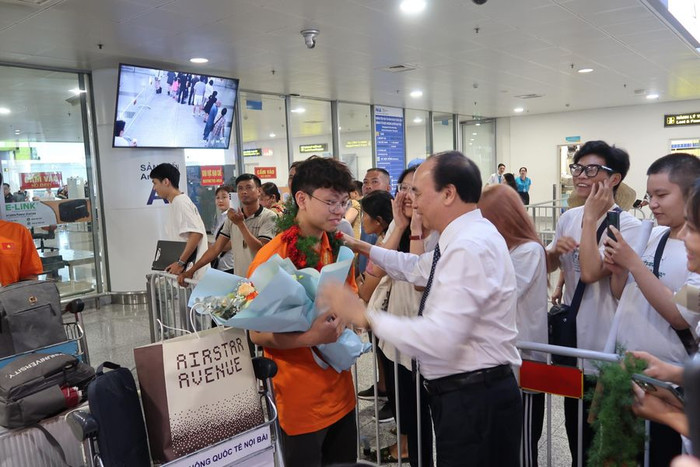 Ông Đỗ Văn Lợi- Phó giám đốc Sở Giáo dục và Đào tạo đã tặng hoa cho em Nguyễn Sĩ Hiếu ngay tại Sân bay quốc tế Nội Bài (Ảnh: CTV) hcv-olympic-hoa-hoc-2.jpeg