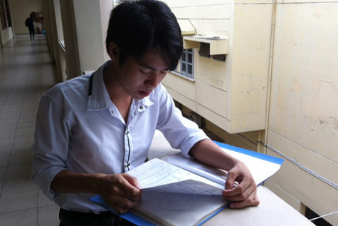 Nguyễn Duy Trung và tập bản nhạc mà các thí sinh khác vứt đi sau mỗi đợt thi. Ảnh : HG.