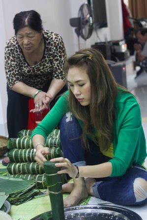 Cô được người thân trong gia đình hỗ trợ trong khi cô gói bánh Cô được người thân trong gia đình hỗ trợ trong khi cô gói bánh