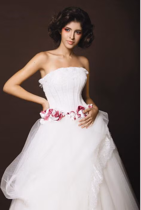 Váy cưới được thiết kế độc đáo. Vòng qua đỏ quanh eo tạo điểm nhấn ấn tượng.