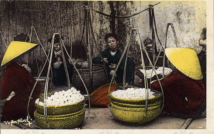 Những người phụ nữ với gánh hàng bán hoa quả rong trên đường phố Hà Nội.