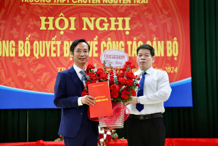 Ông Lương Văn Việt, Giám đốc Sở Giáo dục và Đào tạo Hải Dương trao quyết định bổ nhiệm và tặng hoa chúc mừng thầy giáo Lê Văn Lục nhận nhiệm vụ mới (Ảnh: LT) bo-nhiem.jpg