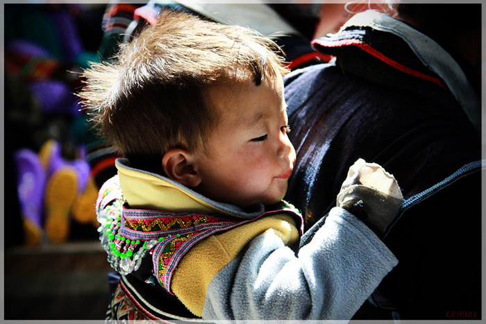 Một nhóc tì người H'Mong đen được mẹ gùi trên đường đến chợ phiên, Một nhóc tì người H'Mong đen được mẹ gùi trên đường đến chợ phiên,