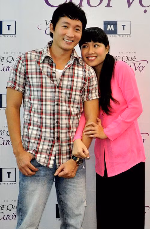 Chiếc áo xẻ tà màu hồng cánh sen kết hợp với quần lụa màu đen trông Kim Khánh cũng e ấp, dịu hiền hơn thường lệ.