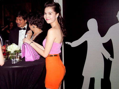 Ngọc Trinh quả là người rất biết mix đồ khi kết hợp áo túi màu hồng nhạt với chiếc váy ôm bó màu cà rốt này. Mái tóc của cô buộc cao tạo cảm giác thanh thoát hơn với đôi vai trần thon thả.