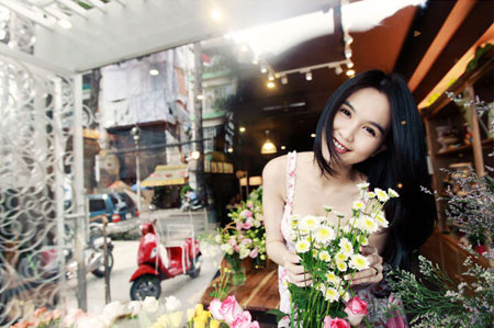 Cô tươi vui, hồn nhiên bên những khóm hoa tươi thắm.