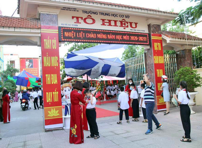 Lãnh đạo Trường Trung học cơ sở Tô Hiệu đón và chỉnh sửa trang phục cho học sinh dự khai giảng ngay tại cổng trường (Ảnh: MT)