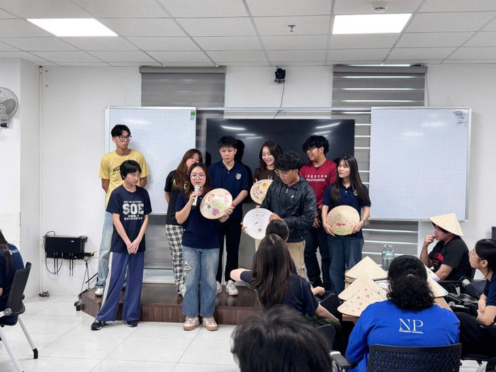 Sinh viên Trường Ngee Ann Polytechnic thực hành trang trí nón lá và giới thiệu về sản phẩm của mình.