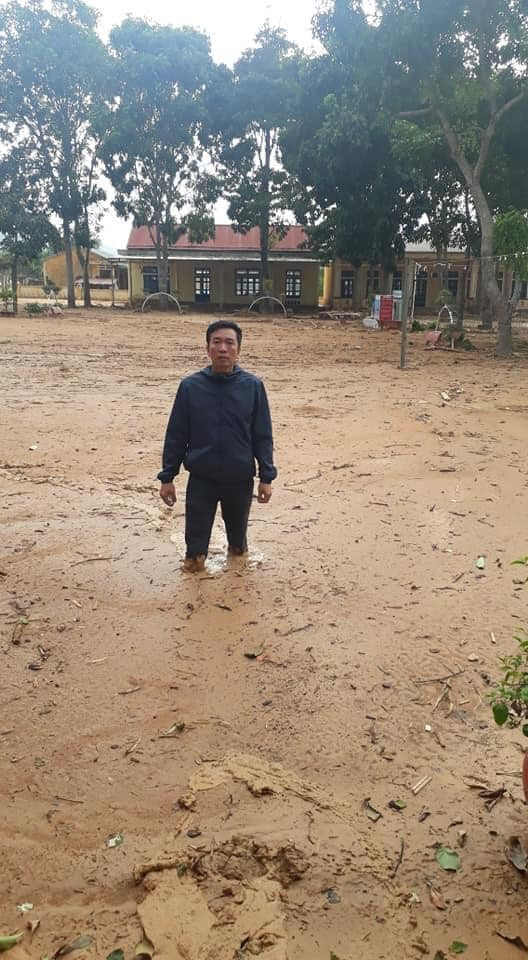 Thầy Nguyễn Văn Tý, hiệu trưởng trường Tiểu học và Trung học cơ sở Hướng Việt đứng gữa sân trường đầy sình, đất gần nửa mét đang vô cùng lo lắng
