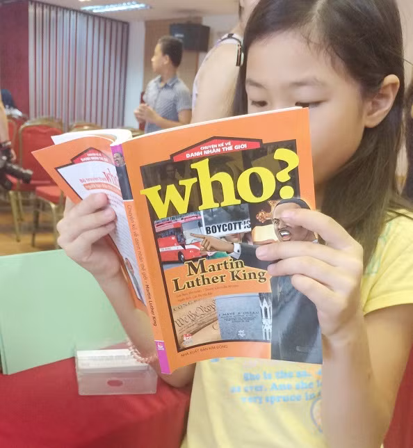 Hình ảnh một em bé say mê đọc sách tại hội thảo. (Ảnh: Ngọc Bích) Hình ảnh một em bé say mê đọc sách tại hội thảo. (Ảnh: Ngọc Bích)
