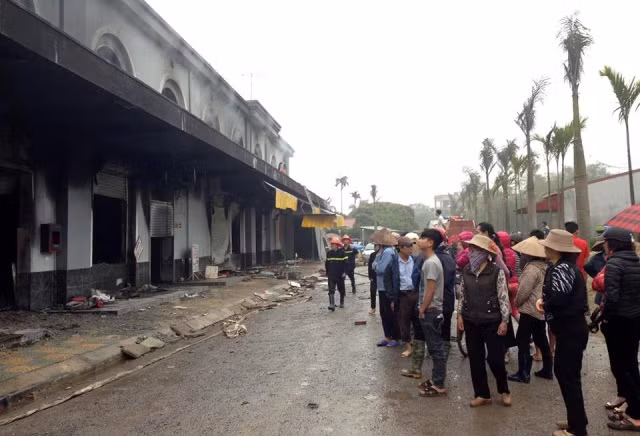 Tiểu thương và người dân xót xa đứng phía ngoài nhìn vào các gian hàng của mình. Tiểu thương và người dân xót xa đứng phía ngoài nhìn vào các gian hàng của mình.