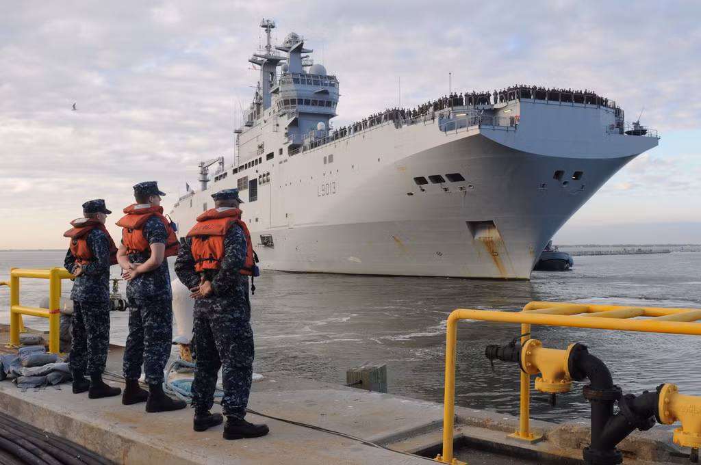 Thủy thủ Mỹ thuộc biên chế của chiến hạm đổ bộ USS Kearsarge (LHD 3) đang kéo chiến hạm đổ bộ FS Mistral (L9013) của Hải quân Pháp khi cập cảng Norfolk ngày 26/1/2012