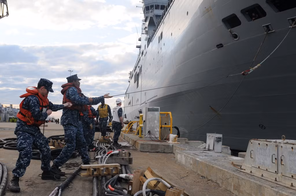 Thủy thủ Mỹ thuộc biên chế của chiến hạm đổ bộ USS Kearsarge (LHD 3) đang kéo chiến hạm đổ bộ FS Mistral (L9013) của Hải quân Pháp khi cập cảng Norfolk ngày 26/1/2012
