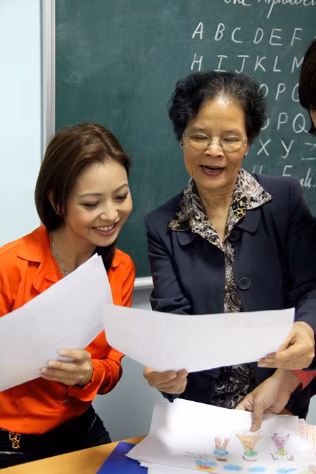 Jennifer Phạm và cô giáo Anh Thơ đang xem xét các bức tranh để trao giải.