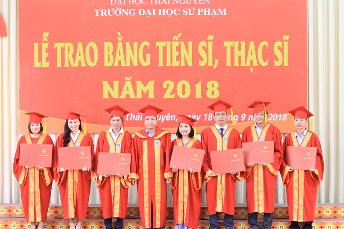 Các tân tiến sĩ chụp ảnh lưu niệm cùng lãnh đạo nhà trường. Ảnh của Xuân Quang.