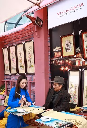 Hoa khôi sinh viên Việt Nam Đặng Mỹ Huyền được trải nghiệm viết thư pháp với sự hướng dẫn của thư pháp gia Trần Quốc Chí.
