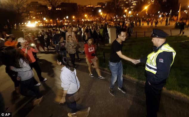 Một người dân gửi lời cảm ơn thông qua cái bắt tay tới một nhân viên cảnh sát Boston tham gia vụ truy lùng nghi phạm đánh bom. Một người dân gửi lời cảm ơn thông qua cái bắt tay tới một nhân viên cảnh sát Boston tham gia vụ truy lùng nghi phạm đánh bom.