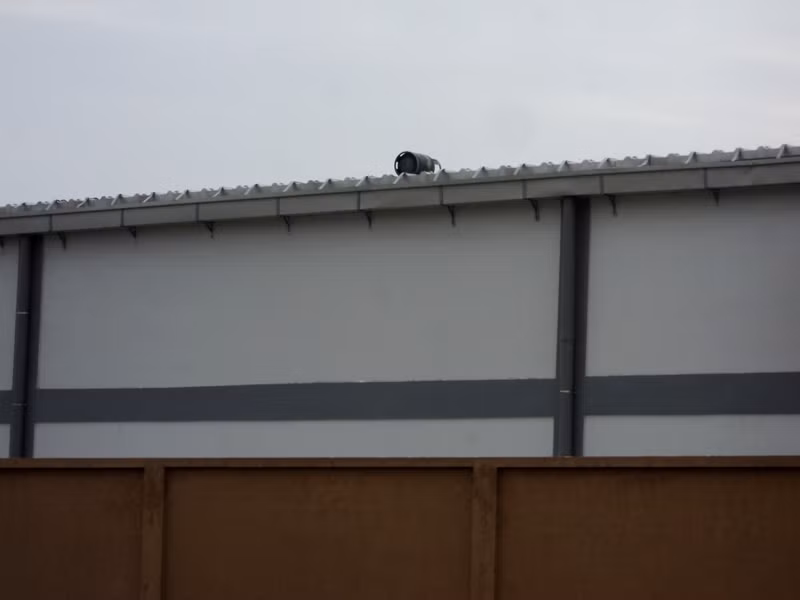 Có bình gas bị bắn mạnh nằm trên nóc một doanh nghiệp cách đó 50 m.